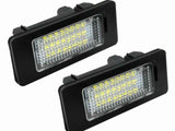 Two rectangular LED license plate lights with black casings and clear lenses are positioned against a white background, showing their grid-like internal structure.