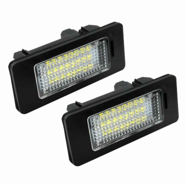 Two rectangular LED license plate lights with black casings and clear lenses are positioned against a white background, showing their grid-like internal structure.