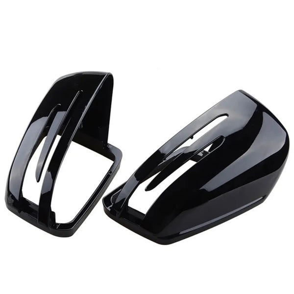 Two glossy black car mirror covers with sleek, aerodynamic slits are placed side by side against a plain white background.