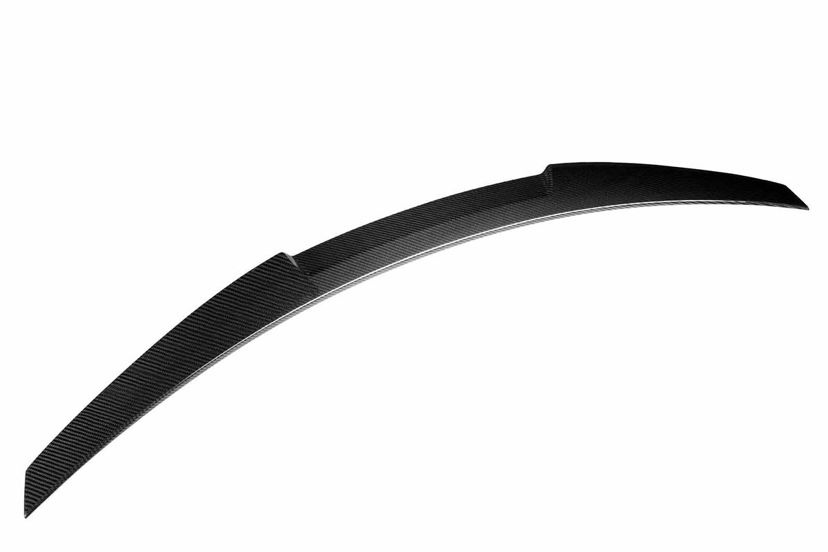 Curved, black carbon fiber spoiler resting against a white background, showing a sleek, aerodynamic design with textured surface detail.