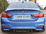 Car viewed from the rear, displaying a blue BMW M4 with dual exhausts; the license plate reads 