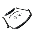 Several black car body kit components are spread out, including a front splitter, side skirts, and bumper lip, arranged on a plain white background.