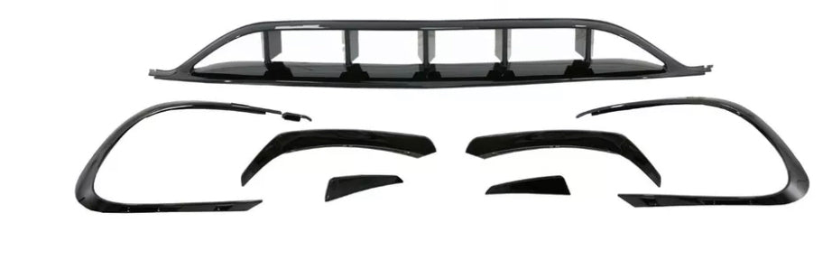 Car body kit components are arranged on a white background, including bumper covers and aerodynamic trim pieces, all in shiny black, designed to enhance vehicle appearance and performance.