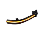 Curved black car headlight with amber LED strip illuminated, set on a plain white background.