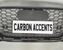Grille with honeycomb pattern displayed on a light background. It features text "CARBON ACCENTS" on a license plate, with "quattro" written below in smaller lettering.