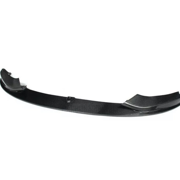A carbon fiber car spoiler, resting on a white background, with a curved structure and raised ends designed for aerodynamic performance.