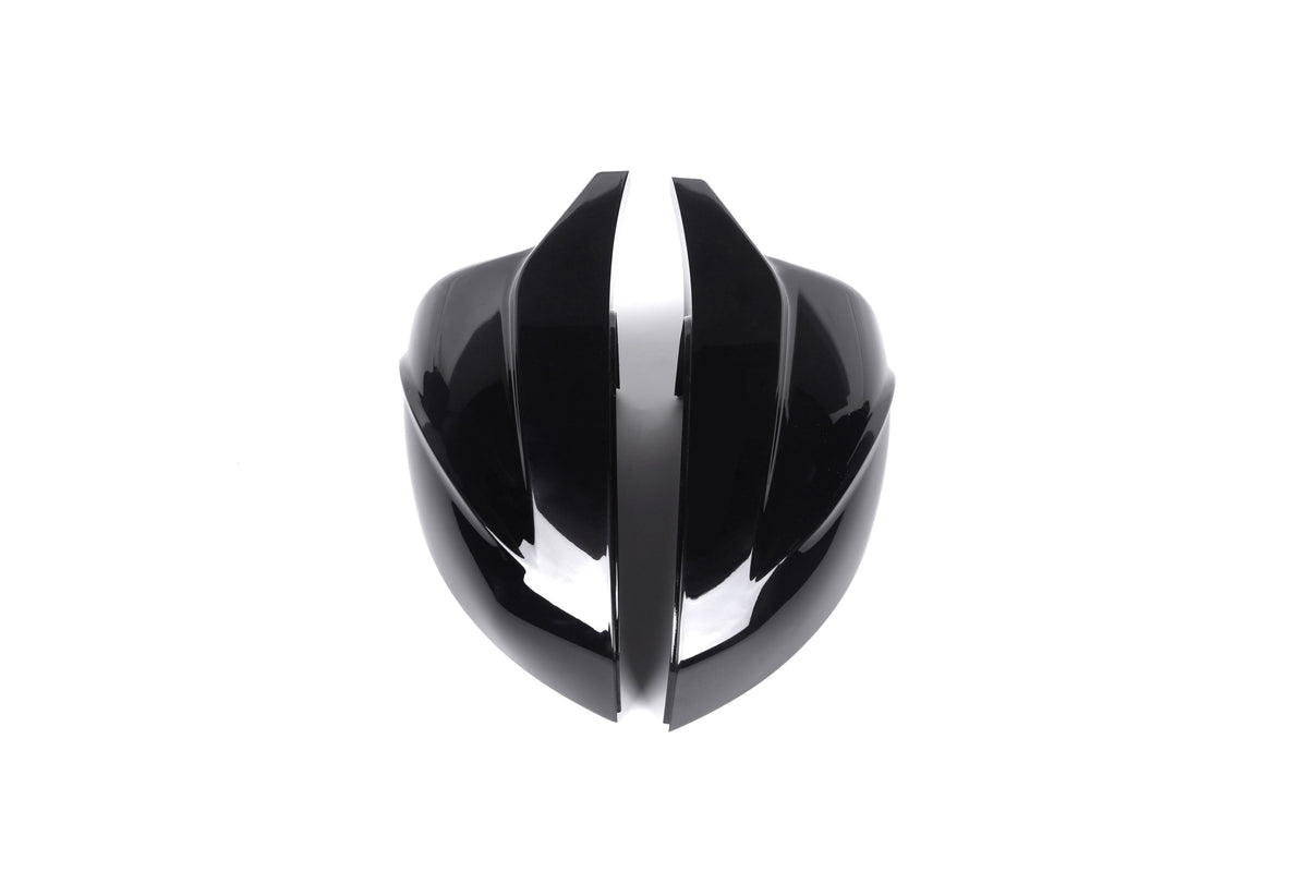 A shiny, black, futuristic helmet with sleek, curved shapes is split down the middle, placed against a plain white background.