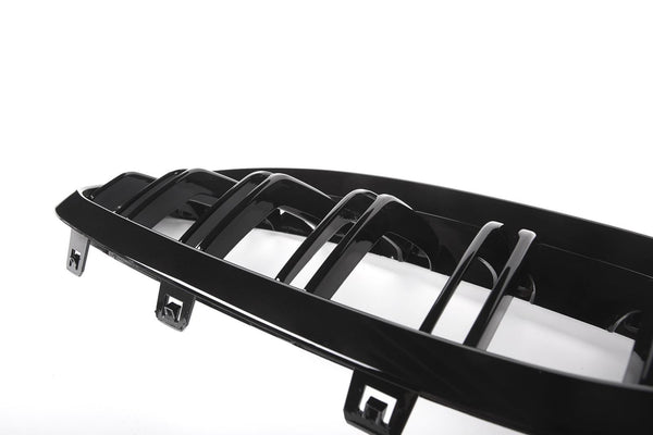 A shiny, black, plastic car grille with seven vertical slats lies against a white background, featuring multiple attachment points at its edges.
