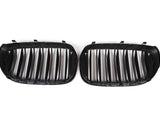 Two black car grille inserts with vertical slats lie side by side against a white background, designed to fit into a vehicle's front end for ventilation.