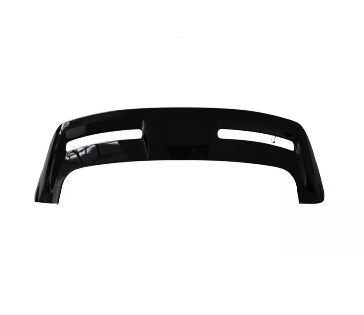 A black automotive bumper with two elongated cutouts lies on a plain, white background, showcasing its smooth surface and contoured design.