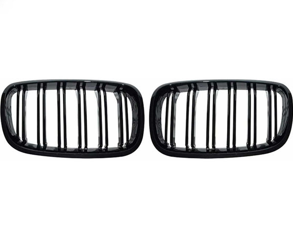 Two black, rectangular car grilles with vertical slats are symmetrically positioned on a plain white background, showcasing a sleek design.