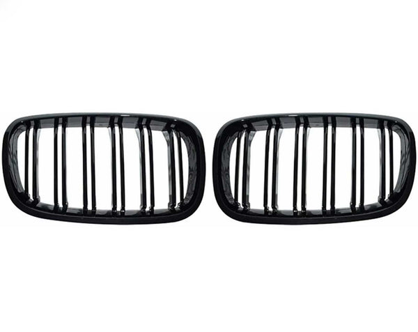 Two black, rectangular car grilles with vertical slats are symmetrically positioned on a plain white background, showcasing a sleek design.