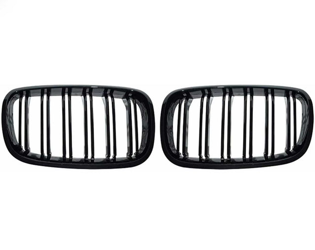 Two black, rectangular car grilles with vertical slats are symmetrically positioned on a plain white background, showcasing a sleek design.