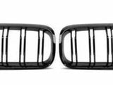 A pair of black car grilles with vertical slats, positioned side by side on a plain white background, designed for air intake on a vehicle's front end.