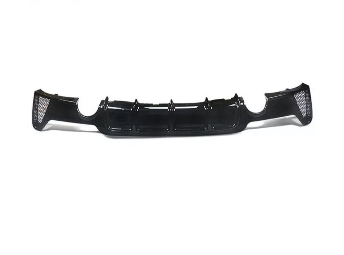A black car bumper diffuser, featuring glossy finish and aerodynamic grooves, rests on a plain white background, showcasing its sleek design and functionality.