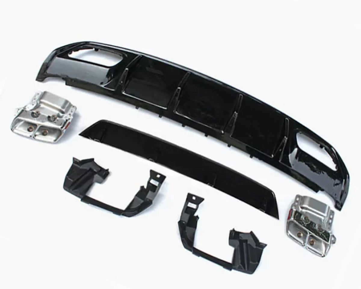 Car bumper components lie on a plain white surface, including black plastic and metallic parts arranged separately, showcasing a disassembled view typical for repairs or upgrades.