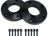 Two black wheel spacers lie side by side, each featuring multiple holes, accompanied by a row of ten matching bolts, against a plain white background.