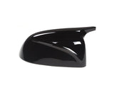 A sleek, glossy black car side mirror cover, angled to the right, placed against a plain white background, reflecting light subtly.