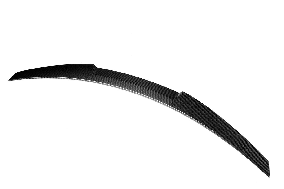 A curved, sleek black spoiler made of carbon fiber is presented against a plain white background, highlighting its aerodynamic design and glossy texture.