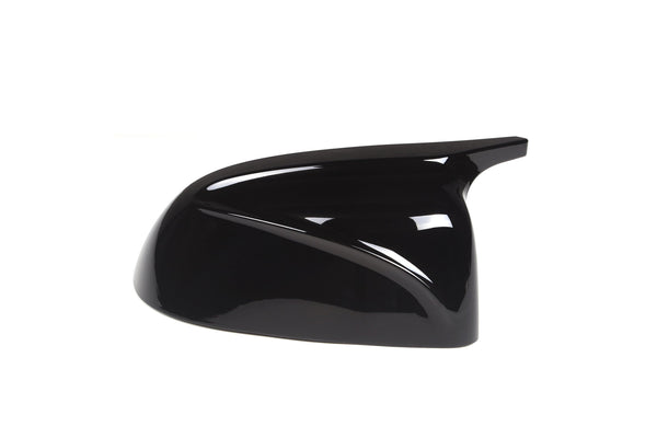 A glossy black side mirror cover with smooth, aerodynamic curves, rests against a plain white background, reflecting light on its surface.