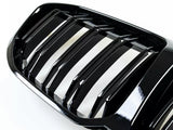A glossy black car grille with vertical slats sits on a white background, showcasing its reflective surface and designed for air intake efficiency in a vehicle's front exterior.