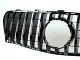 A black car grille features vertical slats and a central circular frame. It is positioned against a plain white background, highlighting its glossy surface and geometric design.