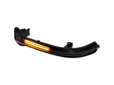 Curved black car indicator light, illuminating with an orange glow, isolated on a white background.