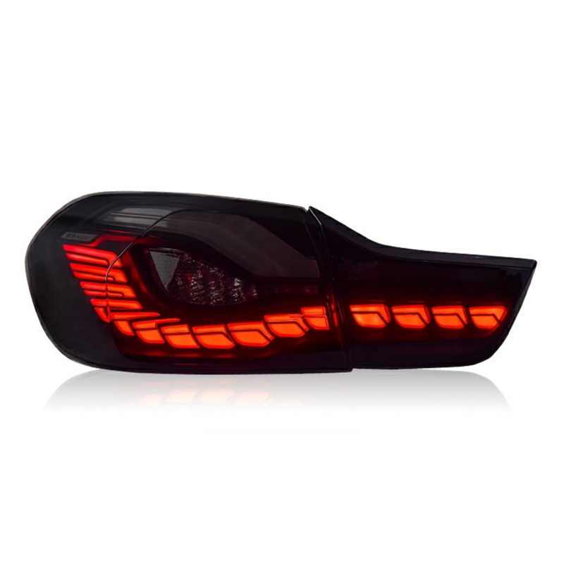 A sleek, smoked car taillight illuminates brightly with red LED lights in an elegant pattern, set against a plain white background.