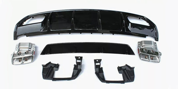 Assorted car parts, including a large black bumper and metallic components, are laid out on a plain white surface, arranged neatly for display or assembly.