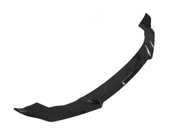 A glossy black car front splitter, designed to enhance aerodynamics, lies against a plain white background.