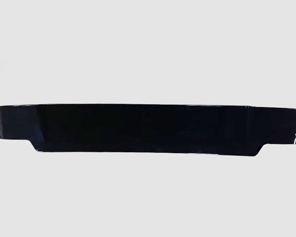 A sleek, black, elongated object lies horizontally, possibly an automotive spoiler or similar accessory, set against a plain light gray background.