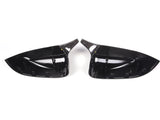 Two glossy black car side mirror covers face each other against a plain white background. The covers are sleek with internal mounting clips visible.