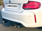 A white BMW with dual exhausts, parked on a sunny road. The license plate reads 
