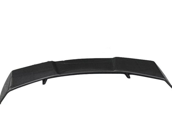 A black car spoiler slightly curved upwards, positioned on a plain white background. The surface has a textured pattern, indicating a potential carbon fiber material.
