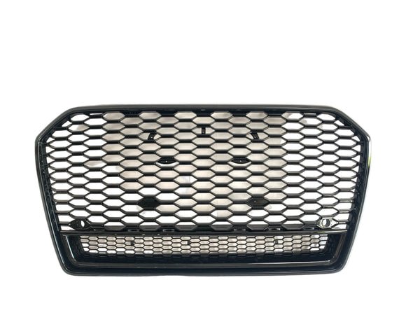 A black, hexagonal-patterned car grille lies against a plain white background, emphasizing its polished surface and open structure.