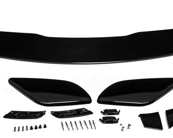 Car spoiler kit with black aerodynamic components laid out on a white surface. Includes a large wing, side pieces, and multiple small parts and screws for assembly.