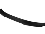 A sleek, black carbon fiber spoiler, slightly curved, sits isolated against a plain white background.