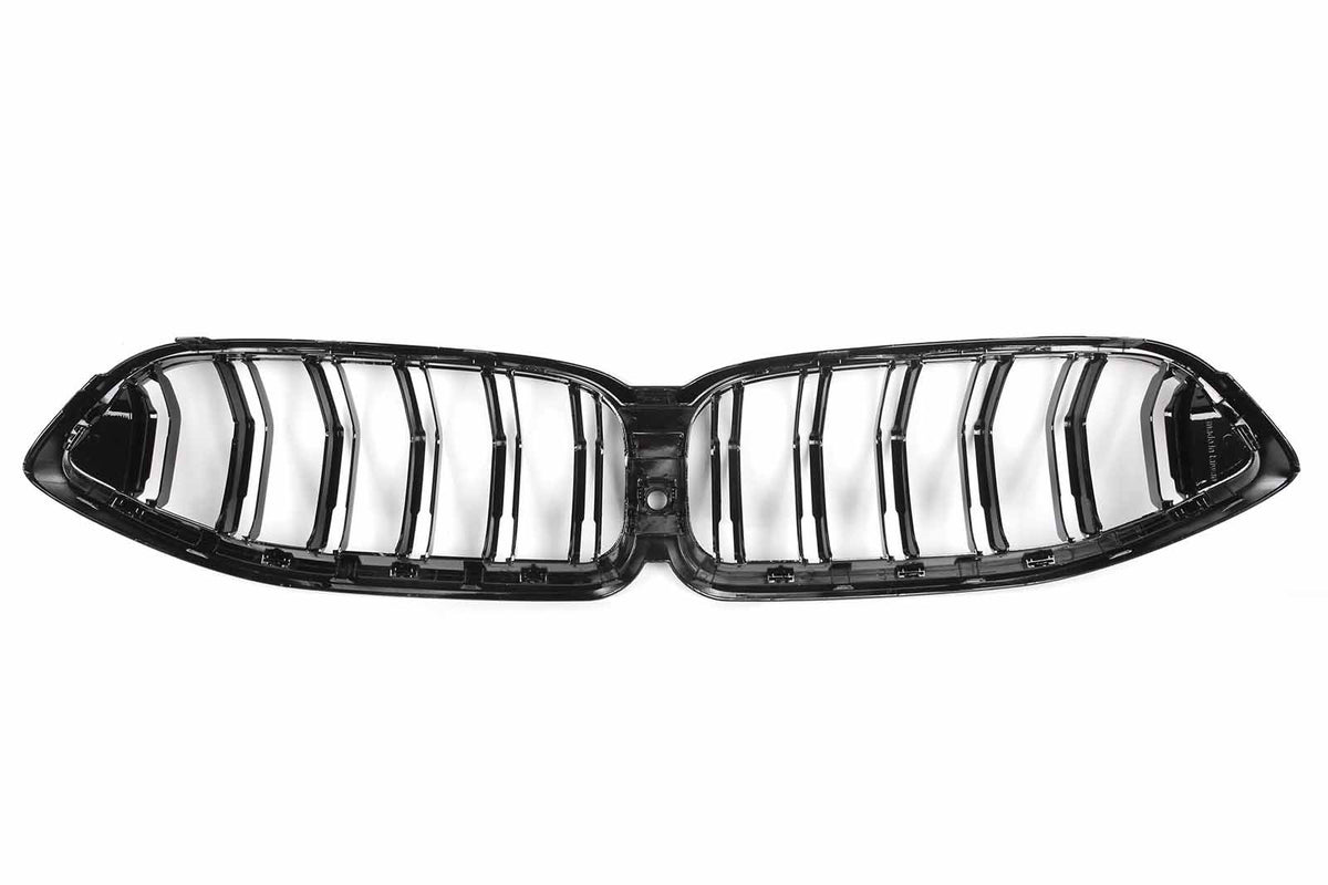 A glossy black car grille with vertical slats lies on a white background, resembling a butterfly shape with symmetrical slots, designed for vehicle front ventilation systems.