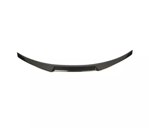 Curved, black carbon fiber car spoiler with a sleek design, resting against a plain white background.