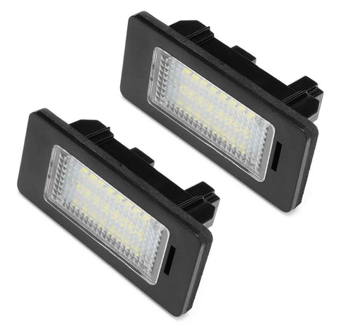 Two rectangular LED license plate lights sit against a white background, featuring black frames and clear, patterned lenses enclosing multiple small yellow LEDs.