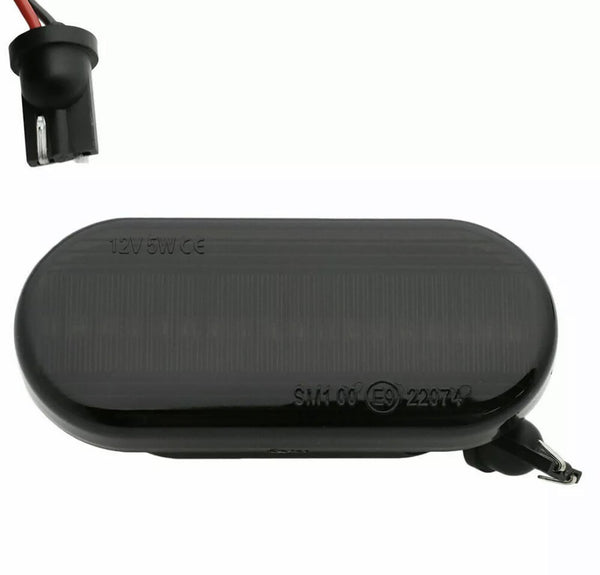 An oval black car side marker light labeled "12V5W CE SM1 06 (E9) 22974," with a socket and exposed wiring, set against a plain background.