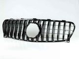 Car grille with vertical black slats and a circular central cutout, resting on a white surface, isolated against a plain white background.
