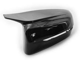 A glossy black car side mirror cover rests on a plain white background, reflecting light and displaying smooth, aerodynamic contours.