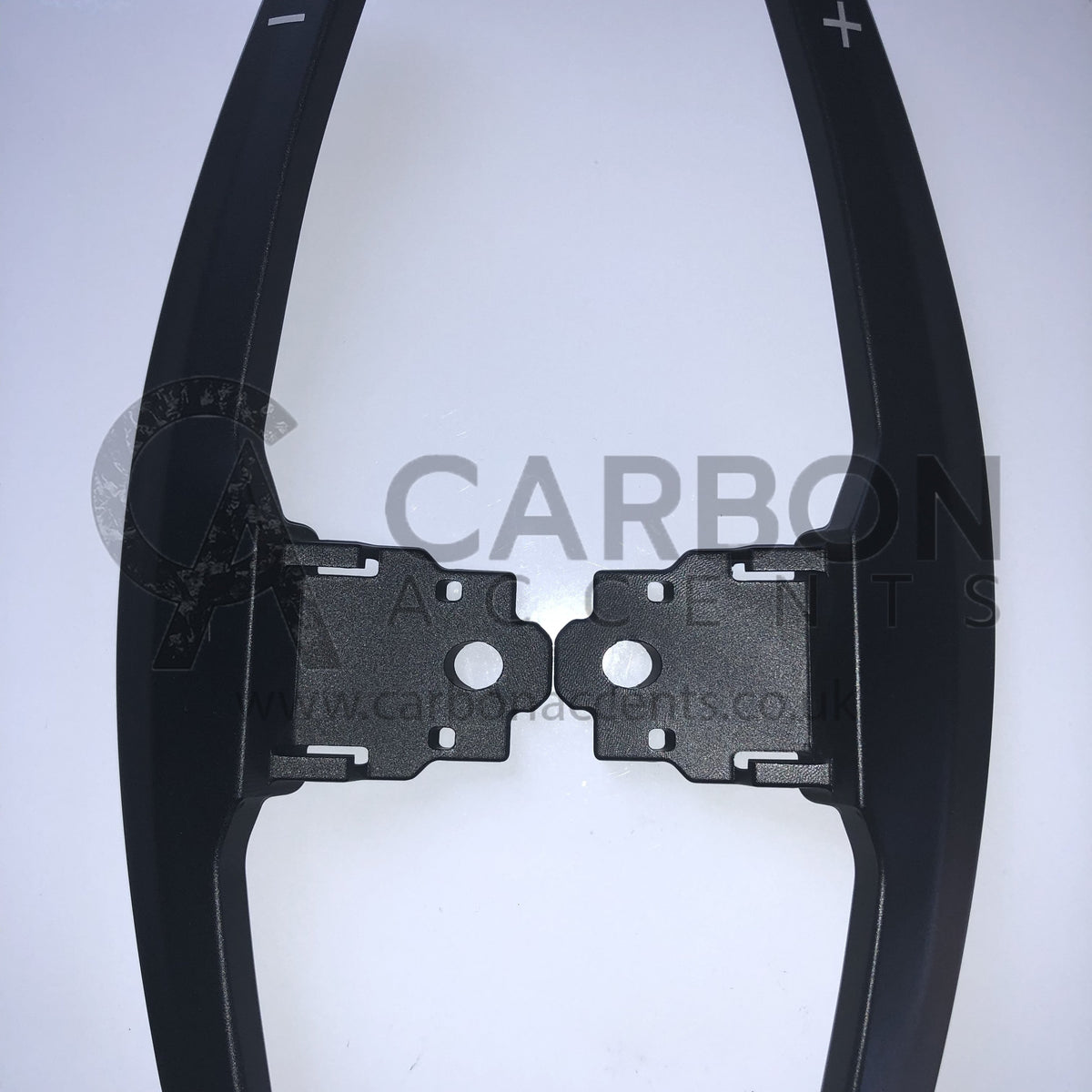Paddle shifters with plus and minus symbols are displayed against a white background. The text reads, "CARBON ANCENTS www.carbonacents.co.uk."