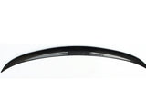 A glossy, black carbon fiber car spoiler arcs gracefully, displayed against a plain white background, highlighting its sleek and aerodynamic design.