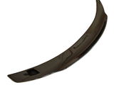 A curved, glossy, black car spoiler rests on a plain white background, appearing sleek and aerodynamic in design.
