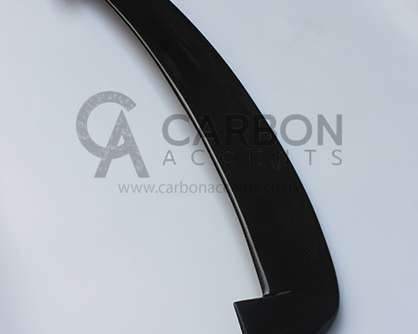A black carbon fiber car spoiler rests on a white background. Text reads: "CARBON ACCENTS," with a website: "www.carbonaccents.co.uk" visible underneath.