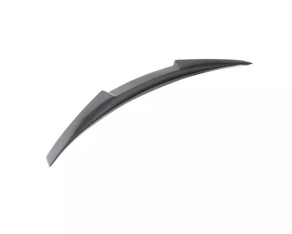Curved carbon fiber car spoiler resting on a plain white background, designed to enhance vehicle aerodynamics.