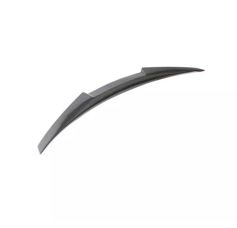 Curved carbon fiber car spoiler resting on a plain white background, designed to enhance vehicle aerodynamics.