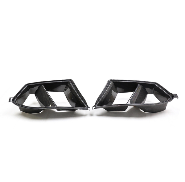 Carbon fiber car exhaust tips with dual openings, facing each other on a plain white background.